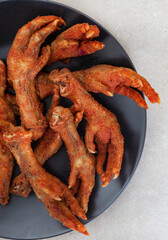 South African township delicacy,  fried chicken feet or walkie talkies with onion and sauce