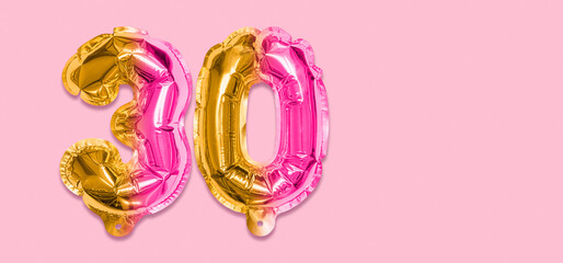 Rainbow foil balloon number, digit thirty on a pink background. Birthday greeting card with inscription 30. Anniversary concept. Top view. Numerical digit. Celebration event, template. Banner