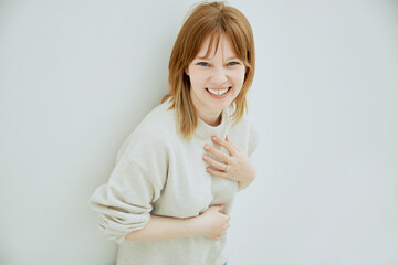 Portrait of young red haired cheerful girl smiling looking at camera over white background.