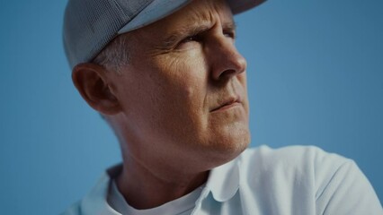 Golfing man face looking distance outdoors. Old senior wear visor cap sportswear