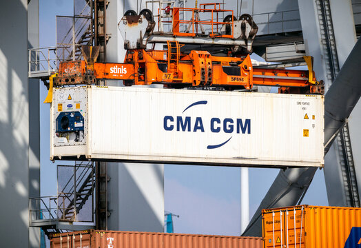 Crane operator unloading a refrigerated container from a cargo ship the Port of Rotterdam. 