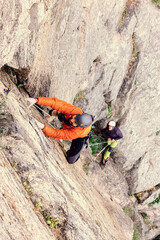 High angle view of two climbers climbing up a rock face.