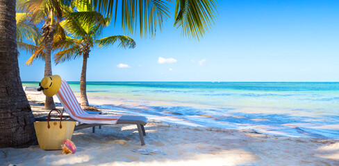 Art Tropical paradise beach with a sun-lounger facing the blue sea - obrazy, fototapety, plakaty