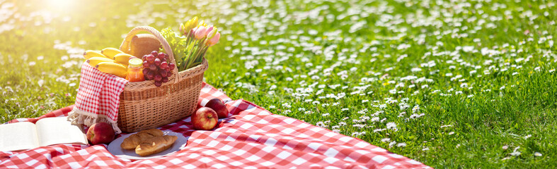 Picnic bascket on the duvet on the meadow in the nature
