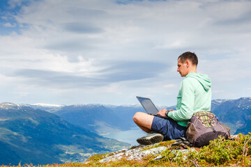 Naklejka na ściany i meble man working outdoors with laptop