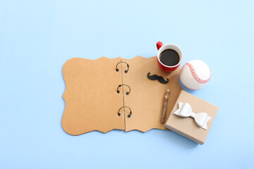 Father's day concept. funny moustache, old photo camera and empty notebook over blue background. top view, flat lay