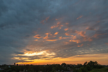 Beautiful orange and blue clouds in sunset over small town