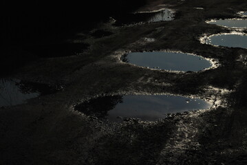 dirt road, bumpy and full of holes, and these holes full of water - obrazy, fototapety, plakaty