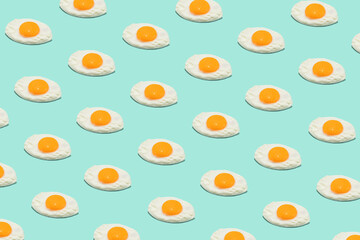 Seamless creative food pattern. Fried eggs on a blue background. Funny colorful breakfast concept.