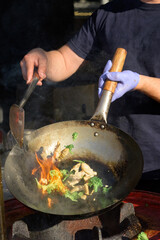 Chef cooks Chinese noodle wok at street food festival