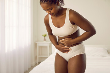 Woman having stomach ache, PMS, period dysmenorrhea cramps, digestive disorder and diarrhea feels...