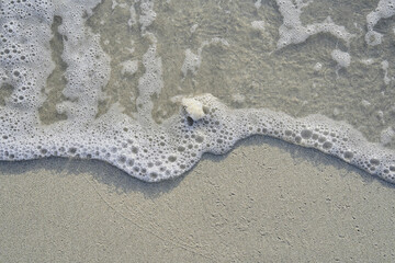 Close-up of white sand, bathed by the gentle waves of the sea. Peguera, municipality of Calviá, Mallorca