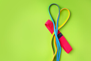 Fitness rubber bands on a green background with copy space