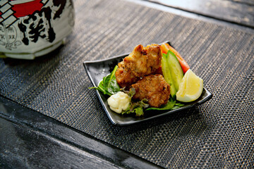 Fried chicken karaage salad with lemon and mayo in the traditional Japanese ramen restaurant, with...