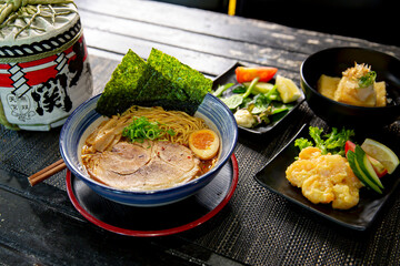 Spicy pork tonkotsu chashu ramen combo with ebi mayo, agedashi tofu in the traditional Japanese ramen restaurant, with Japanese fonts sake barrel translation: Invincible Great Gate