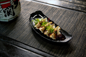 Spicy fried pork gyoza dumplings with salad in the traditional Japanese ramen restaurant, with a...