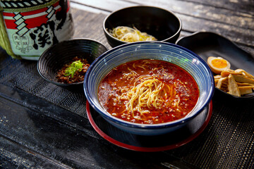 Spicy Sichuan Dandan noodles ramen unassembled in the traditional Japanese ramen restaurant, with a ramen bowl and Japanese fonts sake barrel translation: Invincible Great Gate - obrazy, fototapety, plakaty