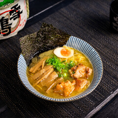 Fried chicken karaage ramen in the traditional Japanese ramen restaurant, with a ramen bowl on a...