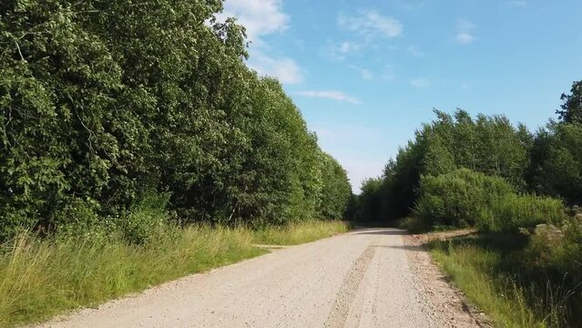 4k POV footage driving along remote gravel road in forest, time lapse