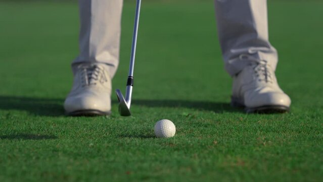 Athlete legs play golf game on green game field. Sport man hitting golfing ball.