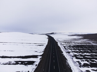 Aerial view of a road with one lane and snow in winter