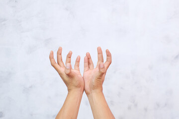 Close-up of a man's hand showing a catch gesture on a gray background