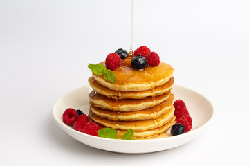 Delicious pancakes with raspberry and blueberry on White background