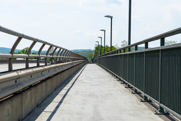 Pedestrian crossing on the highway bridge over the river in West Germany, an empty pavement visible.
