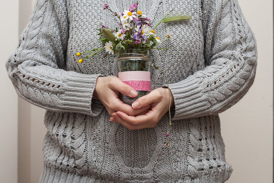 Mujer con ramo de flores silvestres en la mano