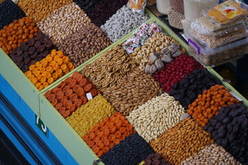 Almaty, Kazakhstan - 03.25.2022 : Different types of dried fruits and nuts in containers for sale in an open market.