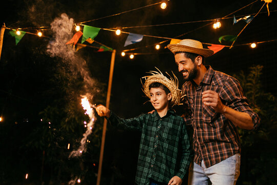 Child playing with fireworks during the traditional Festa Junina in Brazil.