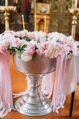 Accessories for christening. The interior of the Orthodox Church at Easter. child baptism. The ceremony is Christian. bathing in a font decorated with fresh flowers