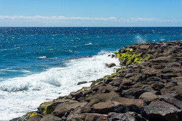 Sea waves breaking against a rock pier in Tenerife Canary Islands.
