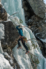 Climber on the top of the frozen waterfall, Norway.
