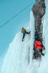 Climber on the top of the frozen waterfall, Norway.