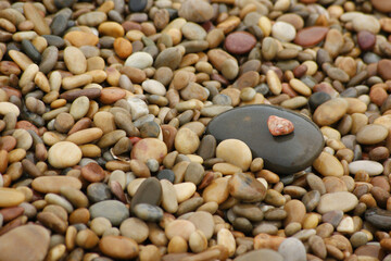 Fototapeta na wymiar It is a stone that has been cut into a round pebble shape as the rock has been broken and eroded by waves and wind over a long period of time. To the touch, it is as smooth as silk.