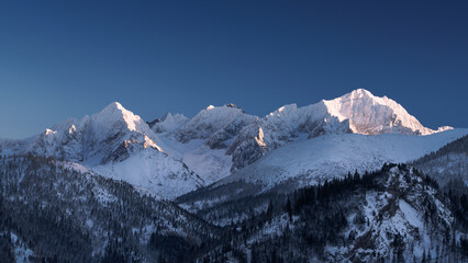 Beautiful rocky mountains with snow. Panorama of winter mountains. Sunset mountains
