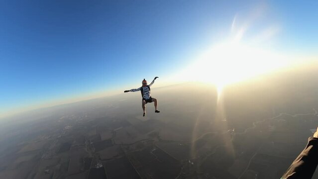 skydiving, acrobatics in the sky, a man in free fall, parachutists fall at sunset
