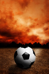 soccer ball on a dry ground and dramatic sky