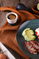 Breakfast with fried eggs with tomato, bacon and avocado