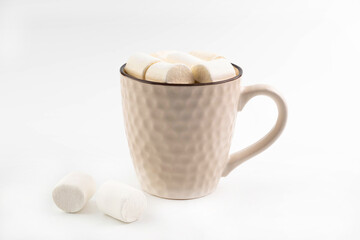 On a white background, a beige cup with cocoa and marshmallows.