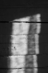 Obraz premium White uneven wooden log wall of rough texture with a sunspot from the window. Country style. Abstract background. Shadow and light. Natural old plank. Gray color. Daylight. Interior. Copy space