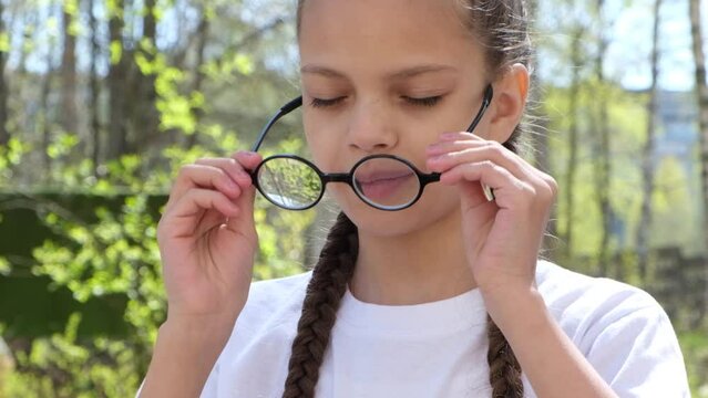 portrait of a cute teenage girl in glasses outdoors