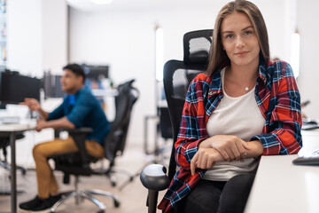 Casual business woman working on desktop computer in modern open plan startup office interior. Selective focus 