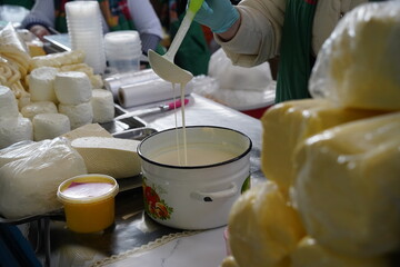 Almaty, Kazakhstan - 03.25.2022 : The seller is stirring sour cream with a ladle in a retail store.