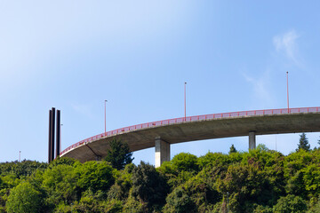 BILBAO, SPAIN-MAY, 5TH, 2022: A8 motorway bridge crossing through the middle of the city under blue sky and trees