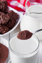 chocolate cocoa milk powder on a white wooden rustic background