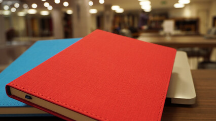 Blue and red notebooks on the desk in the school student library.