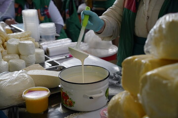 Almaty, Kazakhstan - 03.25.2022 : The seller is stirring sour cream with a ladle in a retail store.