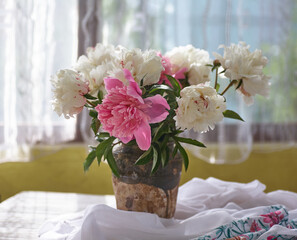 Still life with white and pink peonies in a old ceramic vase